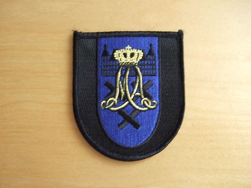 Mouwembleem Cadetteneskadron KMar KMA
Sinds 2017 heeft de Marechaussee een zelfstandig opleidingseskadron op de Koninklijke Militaire Academie (KMA) in Breda. Met het overdragen van de KMar vlag aan commandant KMA werd dat moment gemarkeerd. “Met een eigen eskadron zijn we nu een herkenbare entiteit. Dat is goed voor de onderlinge verbondenheid”, zei luitenant-generaal Harry van den Brink.
Sinds drie jaar wordt de opleiding tot officier bij de KMar gevolgd aan de KMA. Tot vandaag gebeurde dit gezamenlijk met cadetten van andere krijgsmachtdelen.
