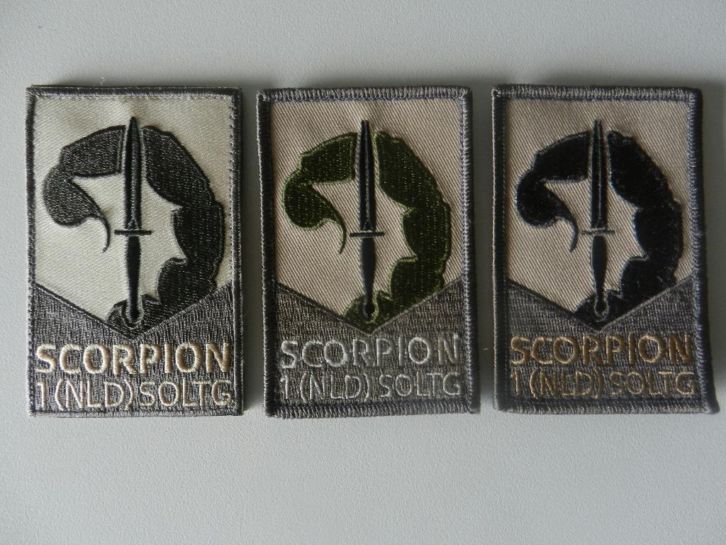 Drie verschillende Scorpionemblemen
De 1e uitvoering is het origineel wat door het KCT is ontworpen en uitgegeven.
De 2e uitvoering is een extra aanmaak in opdracht van de CSM 1e rotatie SOLTG, echter de kleur was fout (groene scorpionstaart)
De 3e uitvoering is toen in opdracht van de CSM 1e rotatie gemaakt, als vervanger van uitvoering 2 en verstrekt aan hen die een 2e embleem wilden hebben.

Met dank aan Pieter Vlam
